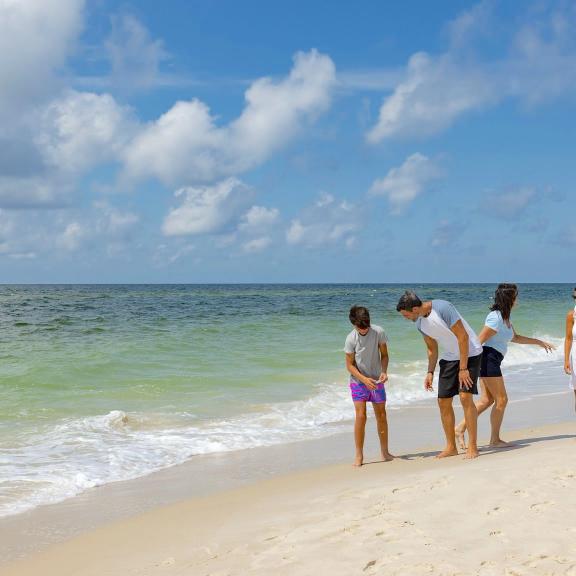 Family walking along the shoreline of the beach in Gulf Shores