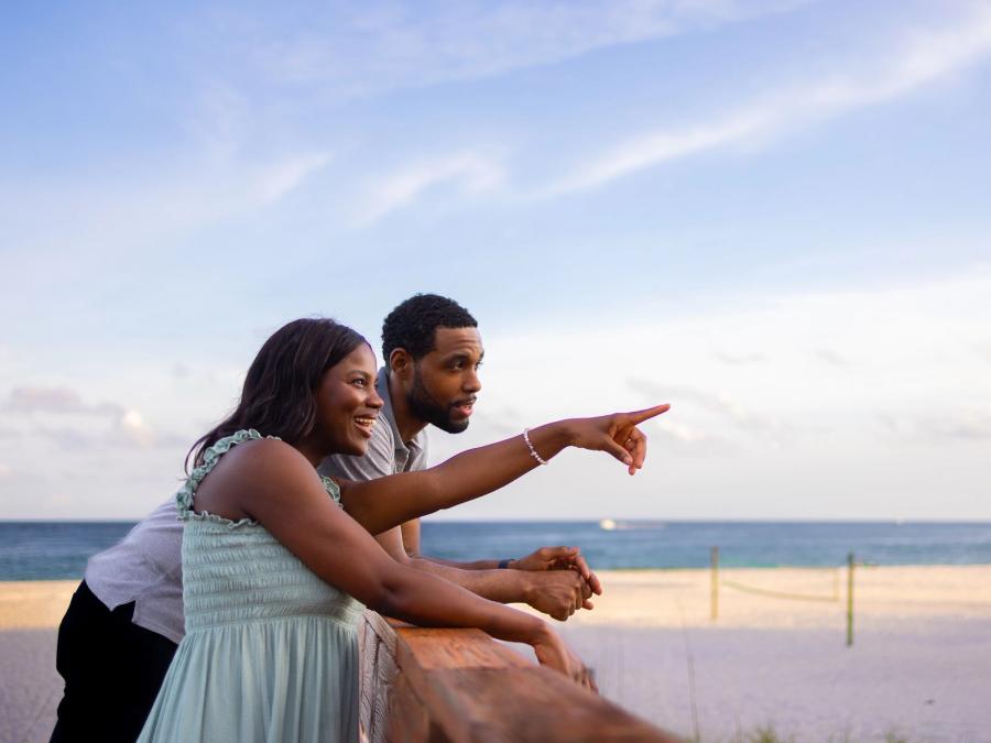 Couple on a boardwalk at the beach during sunset in Orange Beach