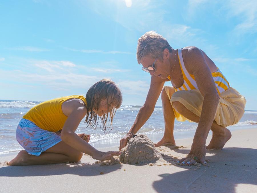grandma and grandkid playing on the beach in gulf shores